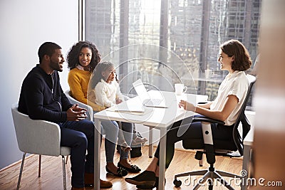 Family Having Consultation With Female Pediatrician In Hospital Office Stock Photo