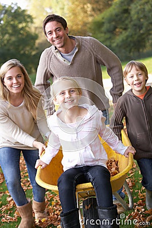 Family having fun with autumn leaves in garden Stock Photo
