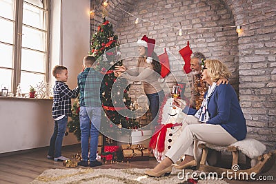 Family having fun on Christmas day, decorating Christmas tree Stock Photo