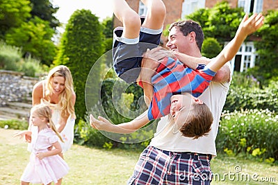 Family Having Fun Playing In Garden Stock Photo