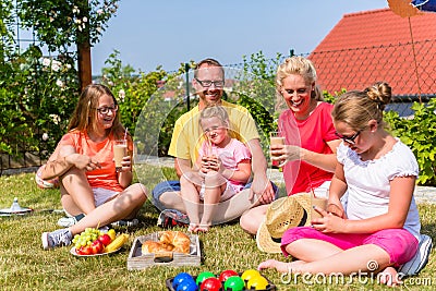 Family having picnic in garden front of their home Stock Photo