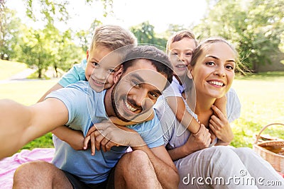 Family having picnic and taking selfie at park Stock Photo