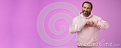 Family in heart. Portrait lovely handsome romantic bearded man in pink hoodie passionatly looking camera show love Stock Photo