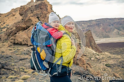 Family hike, mother with baby in backpack Stock Photo