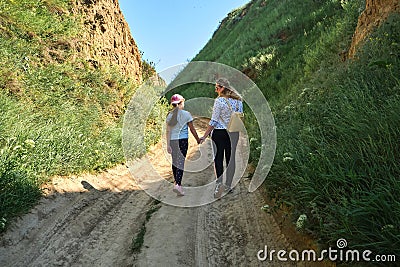 Family hikers walking in the green hills Stock Photo