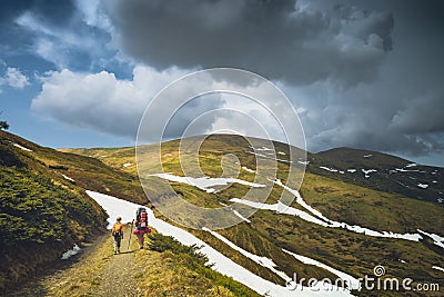 Family hikers walking by the road in a spring mountains Stock Photo