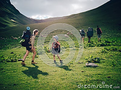 Family hiking in the mountains. A young happy mother and her son take a hike together in the mountains on a beautiful Stock Photo