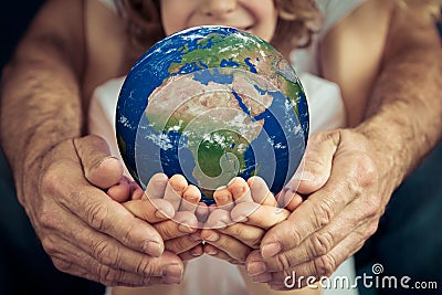 Family holding Earth planet in hands Stock Photo