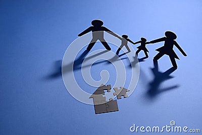 Family holding hands with jigsaw puzzle house Stock Photo