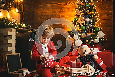 Family holiday. Childhood memories. Santa boy celebrate christmas at home. Boy child play near christmas tree. Merry and Stock Photo