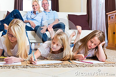 Family at home, the children coloring on floor Stock Photo