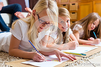 Family at home, the children coloring on floor Stock Photo