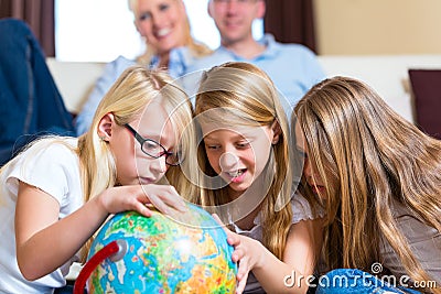 Family at home, the children playing with a globe Stock Photo