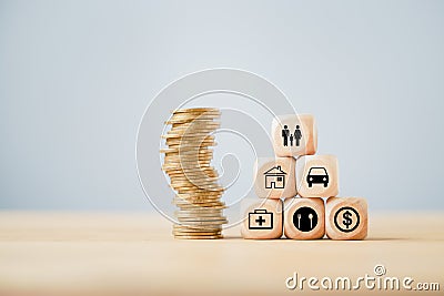 Family icon on top of block pyramid with stack of coins on wood, forfamily insurance , home sweet home, saving, retirement Stock Photo