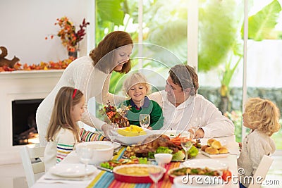 Family with kids at Thanksgiving dinner. Turkey Stock Photo