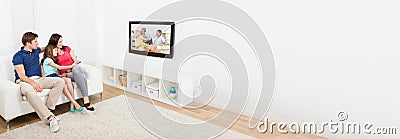 Family With Kids Watching TV In Lounge Room Stock Photo