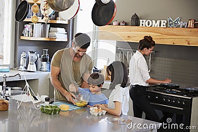 Family In Kitchen Making Morning Breakfast Together Stock Photo