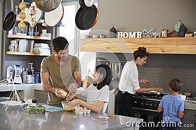 Family In Kitchen Making Morning Breakfast Together Stock Photo