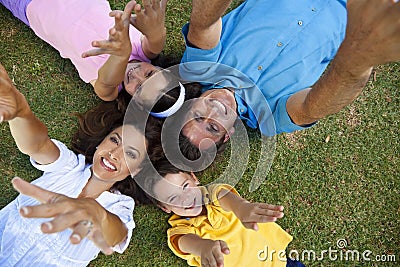 Family Laying Down Hands Up Laughing Stock Photo