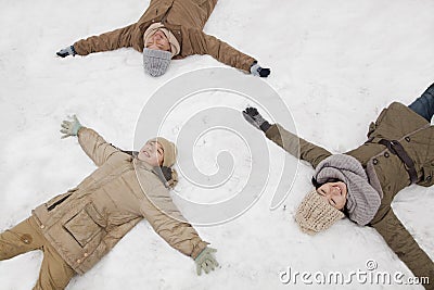 Family laying in snow making snow angels Stock Photo