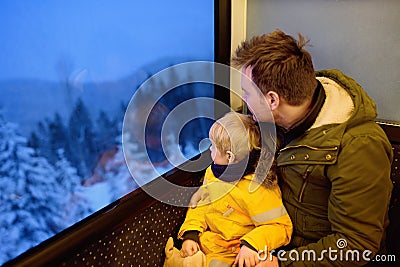 Family looking out of the window of train during travel on cogwheel railway/rack railway in Alps mountains Stock Photo