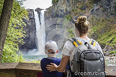 Family looking at a scenic waterfall on a hike together Stock Photo