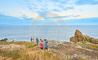 Family looking at the sea at sunset in a landscape of the coast of Galicia. Spain Editorial Stock Photo