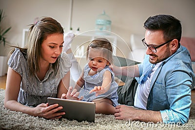 Family lying on the floor with their baby. Stock Photo