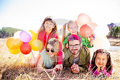 Family lying on grass with balloons Stock Photo