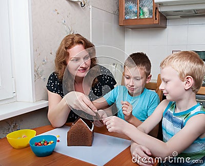 Family making gingerbread house Stock Photo