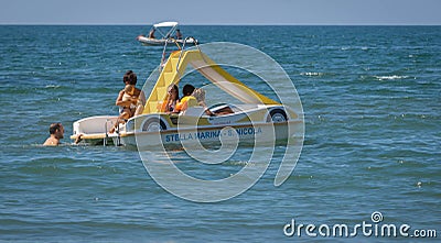 Family on a marine pedal catamaran at Marina San Nicola beach in Italy Editorial Stock Photo