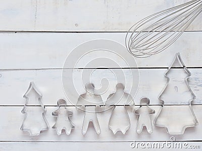 Family metal cookie or biscuit cutter composed of father, mother, brother, sister and pine tree with metal whisk over rough white Stock Photo