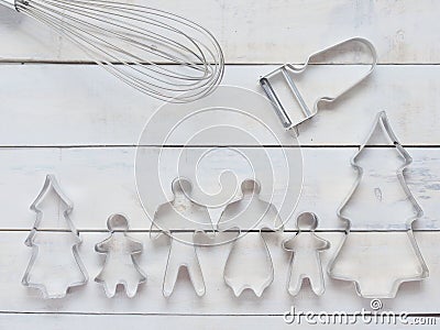 Family metal cookie or biscuit cutter composed of father, mother, brother, sister and pine tree with metal whisk and peeler over r Stock Photo