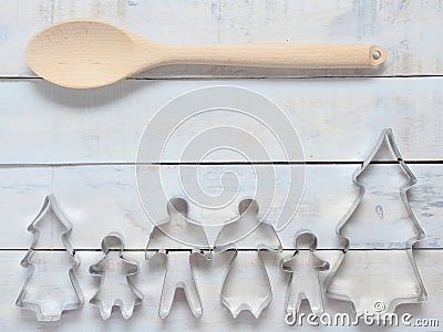 Family metal cookie or biscuit cutter composed of father, mother, brother, sister and pine tree with wooden spoon and fork or ladl Stock Photo