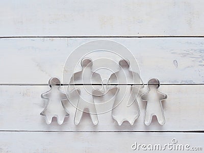 Family metal cookie or biscuit cutter used to cut dough in particular shape composed of father, mother, brother, and sister over r Stock Photo