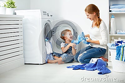 Family mother and child girl little helper in laundry room near washing machine Stock Photo