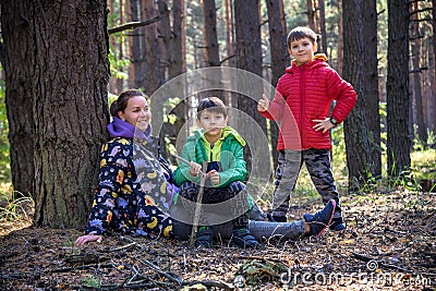 Family with mother and two children boy sibling brothers sits in Stock Photo