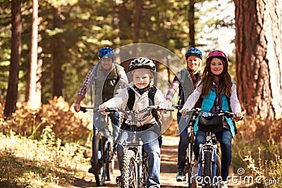 Family mountain biking on forest trail, front view Stock Photo