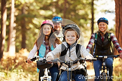 Family mountain biking on forest trail, front view, close-up Stock Photo