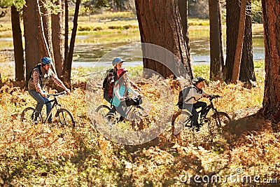 Family mountain biking past lake, Big Bear, California, USA Stock Photo