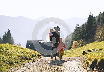 Family in nature outdoor. Woman with kids on hiking trail in mountains Stock Photo