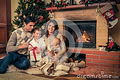 Family near fireplace in Christmas decorated house Stock Photo