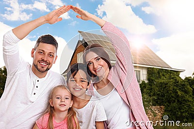 Family near their house with solar panels. Alternative energy source Stock Photo