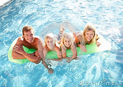 Family Outside Relaxing In Swimming Pool Stock Photo