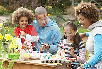 Family Painting Easter Eggs In Gardens Stock Photo