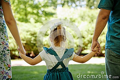 Family, parenthood, adoption and people concept. happy mother, father and little girl walking in summer park Stock Photo