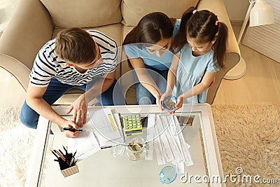 Family with pay bills, calculator and money counting expenses indoors. Money savings concept Stock Photo