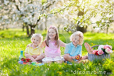 Family picnic in spring park. Kids eating outdoors Stock Photo