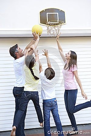 Family Playing Basketball Outside Garage Stock Photo