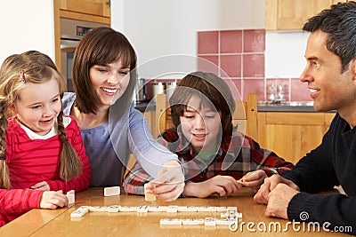 Family Playing Dominoes In Kitchen Stock Photo